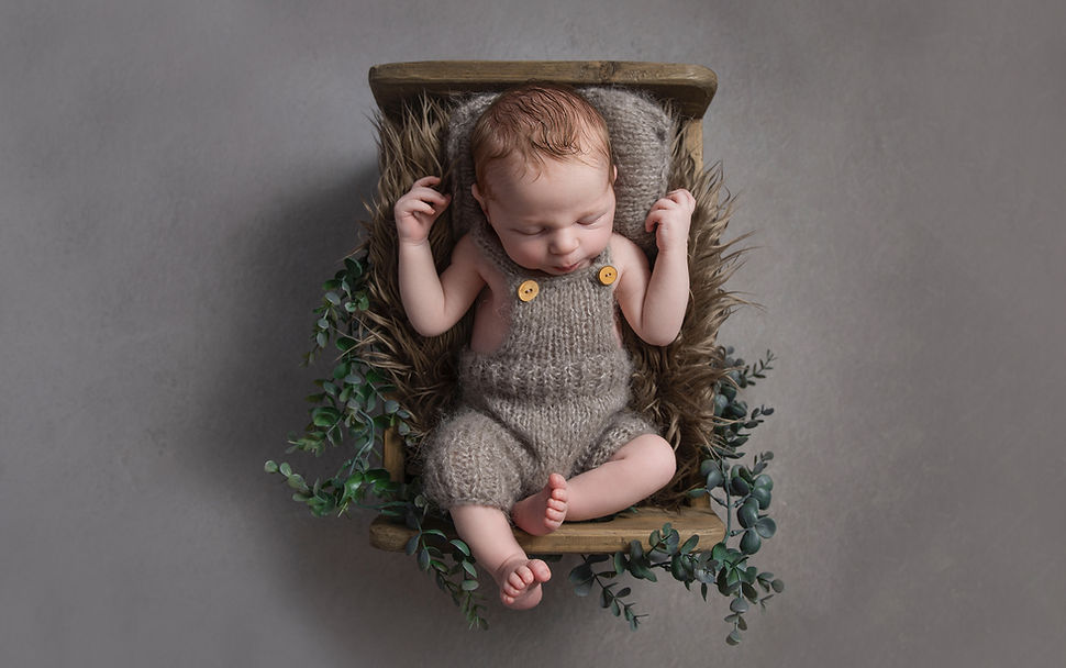 Boy sleeping in baby bed during newborn photography session Belfast Northern Ireland.jpg